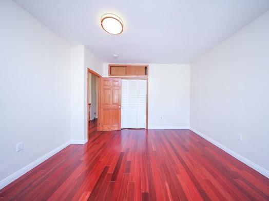 299 Bay 13th St, Brooklyn, NY 11214 - unfurnished bedroom featuring wood finished floors, baseboards, and a closet