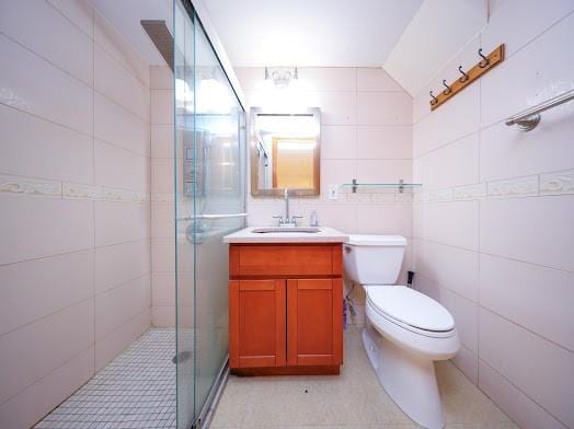 299 Bay 13th St, Brooklyn, NY 11214 - bathroom featuring tile walls, vanity, a stall shower, toilet, and vaulted ceiling