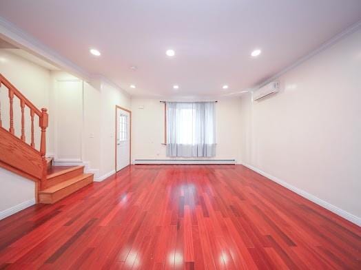 299 Bay 13th St, Brooklyn, NY 11214 - empty room featuring baseboard heating, a wall unit AC, wood finished floors, stairs, and baseboards