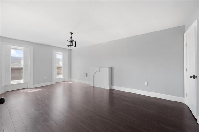 interior space featuring baseboards and dark wood-style floors