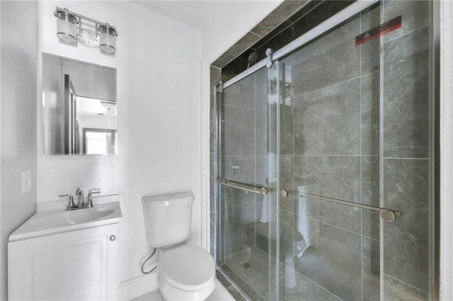 bathroom with vanity, a stall shower, and toilet