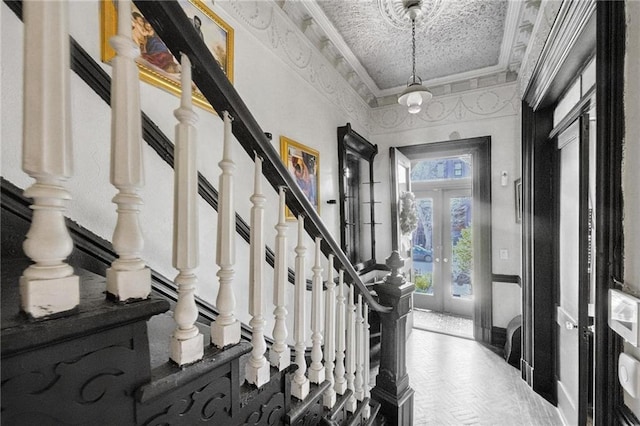 foyer entrance with french doors, stairs, and crown molding