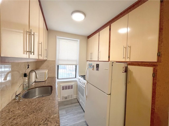 3101 Ocean Pkwy Unit 4O, Brooklyn, NY 11235 - kitchen with a sink, white appliances, radiator, light wood-style flooring, and backsplash