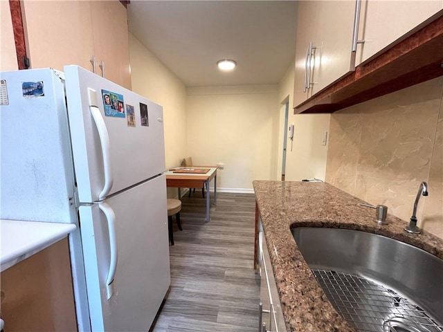 3101 Ocean Pkwy Unit 4O, Brooklyn, NY 11235 - kitchen featuring freestanding refrigerator, a sink, wood finished floors, dark stone countertops, and baseboards