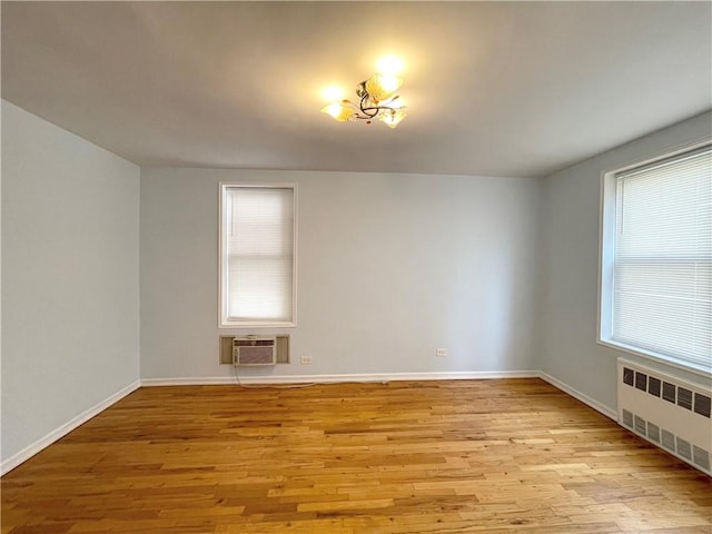 3101 Ocean Pkwy Unit 4O, Brooklyn, NY 11235 - spare room with radiator heating unit, a wall mounted AC, wood finished floors, and baseboards