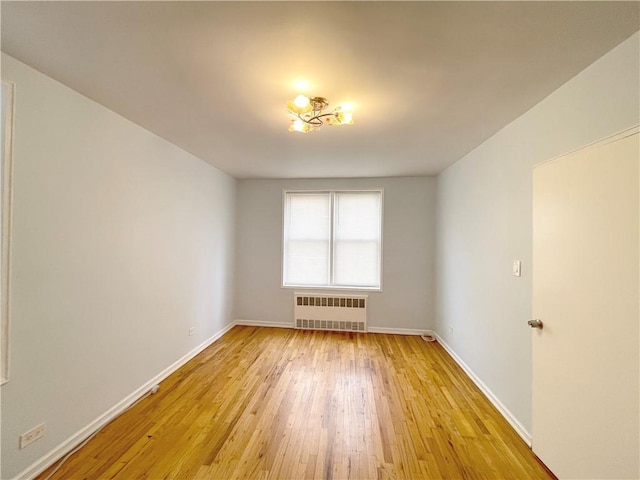3101 Ocean Pkwy Unit 4O, Brooklyn, NY 11235 - spare room featuring radiator heating unit, light wood-style flooring, and baseboards
