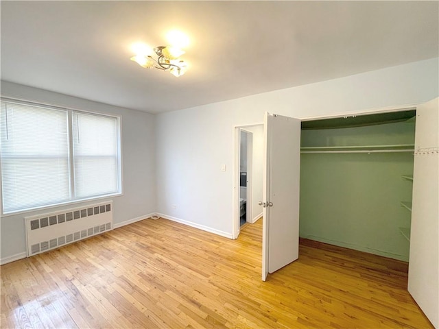 3101 Ocean Pkwy Unit 4O, Brooklyn, NY 11235 - unfurnished bedroom featuring radiator, light wood-type flooring, a closet, and baseboards