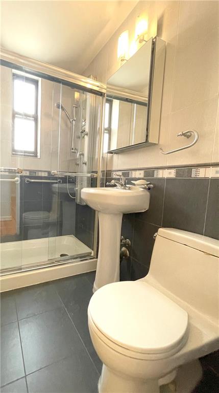 3101 Ocean Pkwy Unit 4O, Brooklyn, NY 11235 - bathroom featuring a shower stall, toilet, and tile patterned flooring