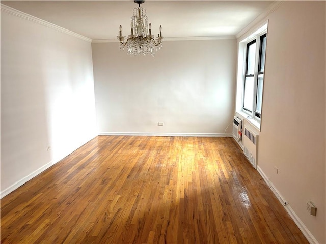 unfurnished dining area with a chandelier, wood-type flooring, crown molding, baseboards, and radiator heating unit