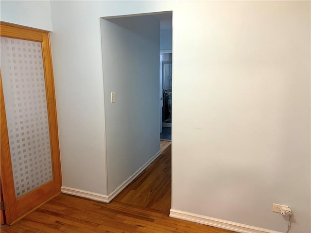 hallway with baseboards and wood finished floors
