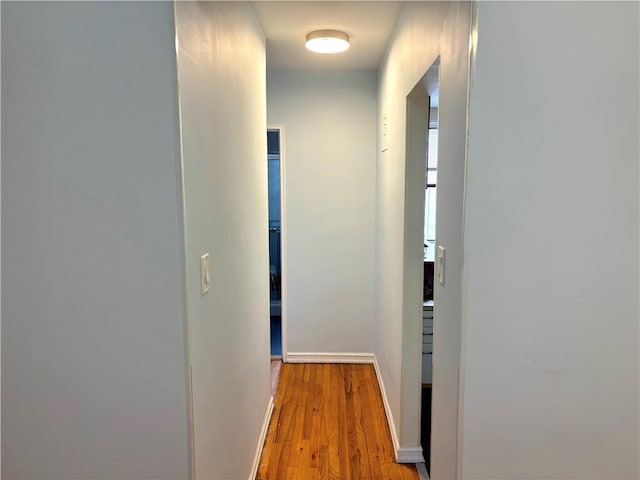 hall featuring wood finished floors and baseboards