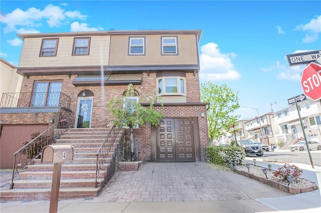 view of front facade featuring brick siding, a garage, and stairway