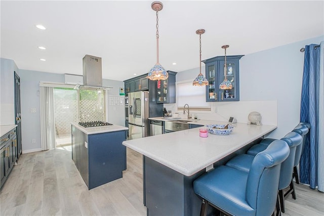 kitchen with light wood-style floors, a center island, stainless steel appliances, island exhaust hood, and glass insert cabinets