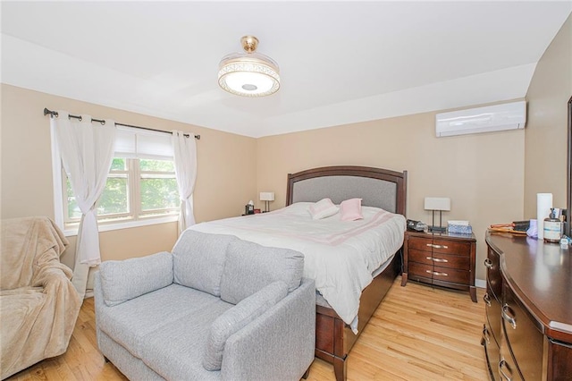 bedroom with a wall mounted AC and light wood-style flooring