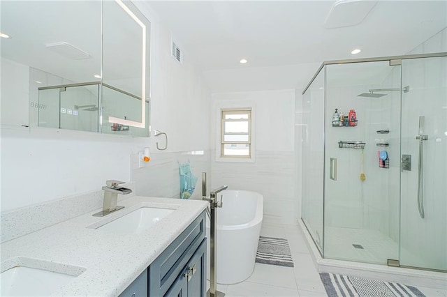 full bath featuring visible vents, tile patterned floors, a soaking tub, a sink, and a stall shower