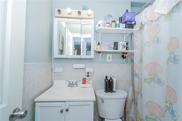 full bath with vanity, wainscoting, toilet, and tile walls