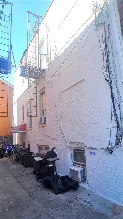 exterior space with brick siding and cooling unit