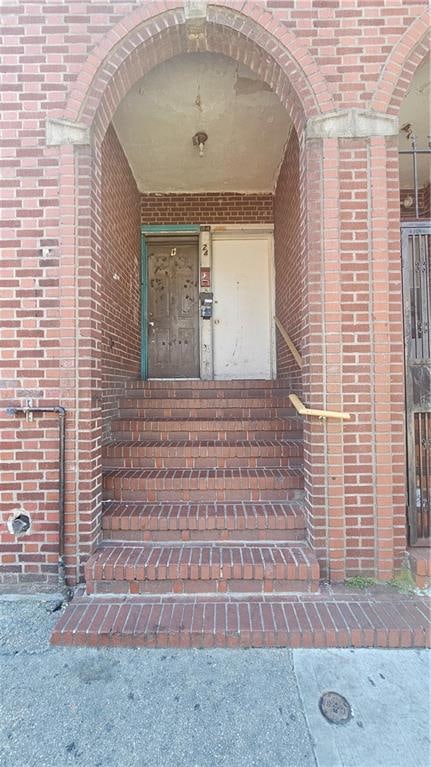 doorway to property with brick siding