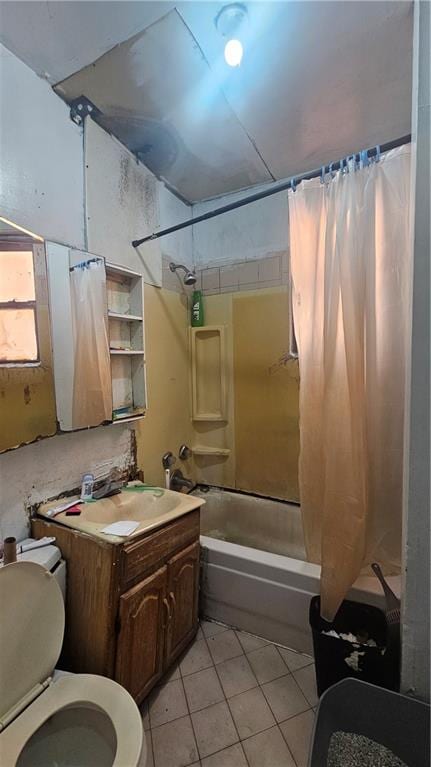 full bath featuring shower / bath combo with shower curtain, tile patterned floors, toilet, and vanity