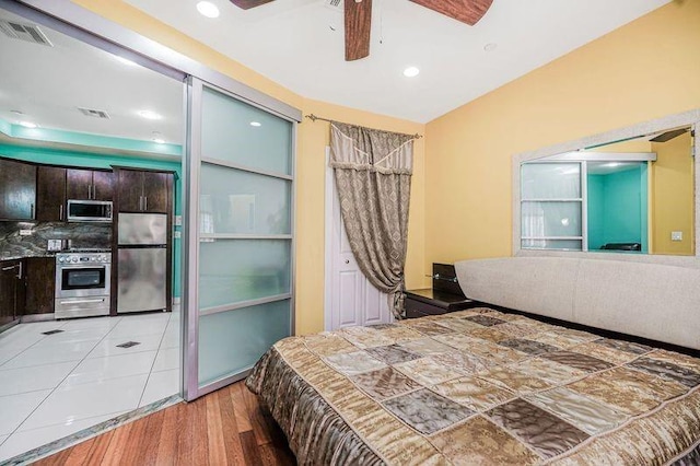 bedroom with freestanding refrigerator, recessed lighting, visible vents, and light wood finished floors