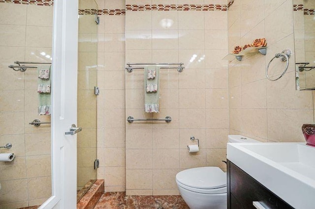 bathroom featuring toilet, tile walls, a shower stall, and vanity