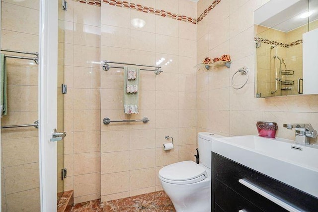 bathroom featuring tile walls, a stall shower, vanity, and toilet