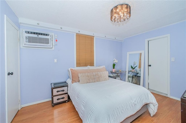 1960 Stillwell Ave, Brooklyn, NY 11223 - bedroom featuring light wood-type flooring, crown molding, a chandelier, a wall unit AC, and a textured ceiling