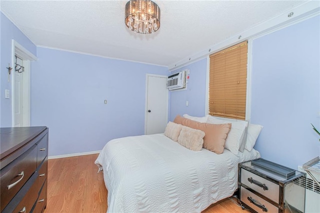 1960 Stillwell Ave, Brooklyn, NY 11223 - bedroom with an AC wall unit, ornamental molding, light wood-type flooring, a textured ceiling, and a chandelier