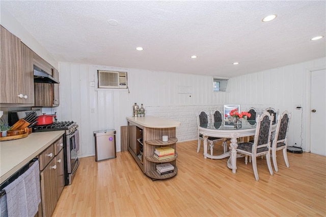 1960 Stillwell Ave, Brooklyn, NY 11223 - kitchen featuring gas range, light wood-style flooring, a textured ceiling, light countertops, and an AC wall unit