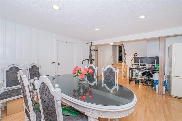 1960 Stillwell Ave, Brooklyn, NY 11223 - dining room featuring light wood-type flooring, a textured ceiling, stairs, recessed lighting, and a fireplace