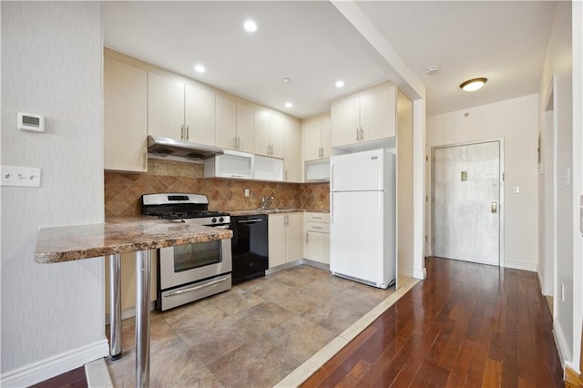 2408 Ocean Ave Unit 12, Brooklyn, NY 11229 - kitchen with freestanding refrigerator, stainless steel gas stove, dishwasher, under cabinet range hood, and baseboards