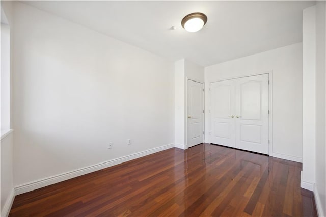 unfurnished bedroom with baseboards, a closet, and wood finished floors