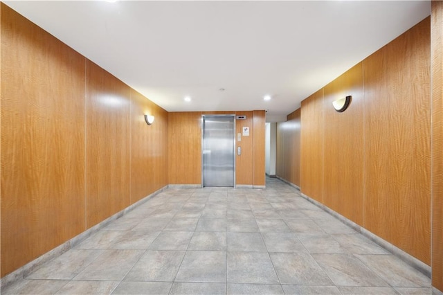 interior space featuring elevator and wood walls