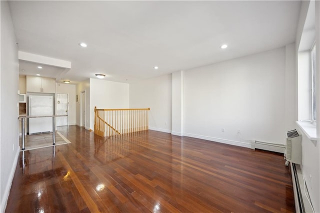 unfurnished room with baseboards, recessed lighting, baseboard heating, and hardwood / wood-style floors