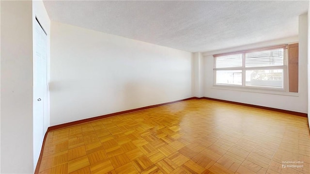 empty room with baseboards and a textured ceiling