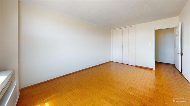 unfurnished bedroom with a closet and baseboards
