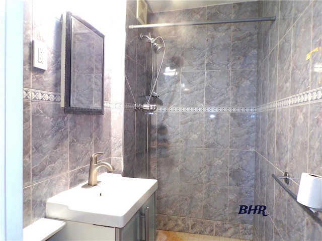 bathroom featuring vanity, tile walls, and tiled shower