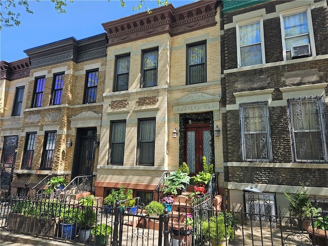 view of property with brick siding and a fenced front yard