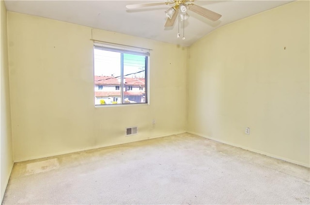 carpeted empty room with visible vents, baseboards, ceiling fan, and lofted ceiling