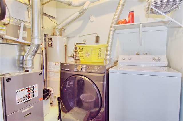 clothes washing area featuring laundry area, water heater, and washing machine and dryer