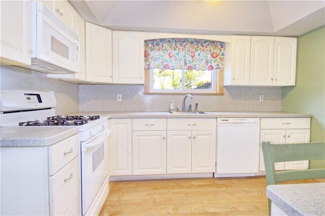 kitchen featuring backsplash, a sink, light countertops, white cabinets, and white appliances