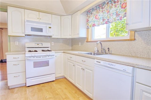 kitchen with a sink, light wood finished floors, white appliances, and white cabinetry