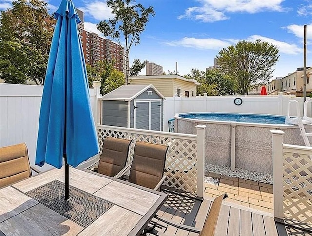 view of swimming pool featuring a fenced in pool, a fenced backyard, an outbuilding, and a storage shed