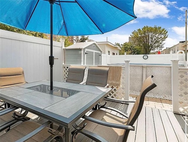 wooden terrace with outdoor dining space and a fenced backyard