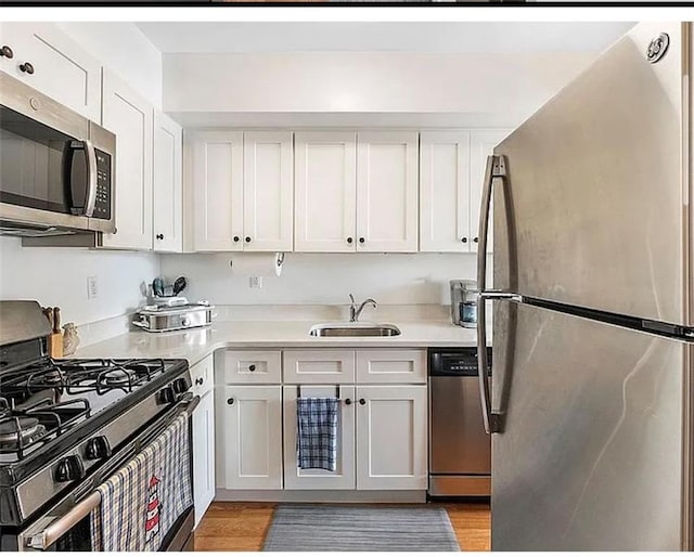 3626 Bayview Ave, Brooklyn, NY 11224 - kitchen featuring stainless steel appliances, a sink, light countertops, and white cabinetry