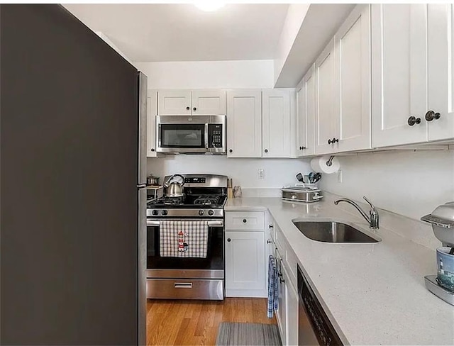 3626 Bayview Ave, Brooklyn, NY 11224 - kitchen with appliances with stainless steel finishes, a sink, light countertops, and white cabinets