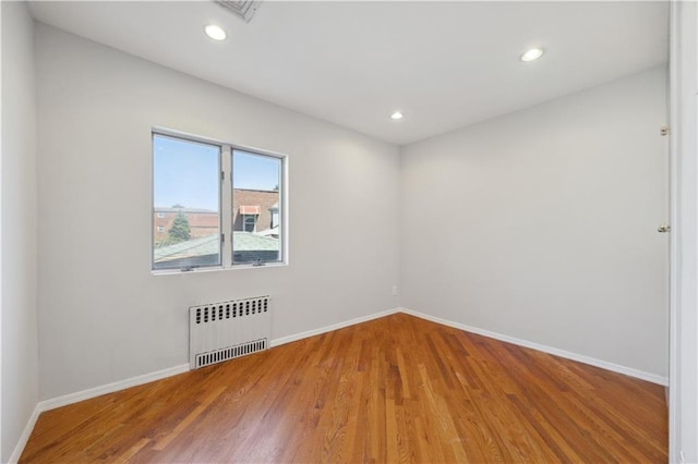 2680 E 23rd St, Brooklyn, NY 11235 - unfurnished room featuring radiator, baseboards, wood finished floors, and recessed lighting