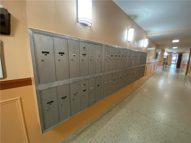 hall featuring speckled floor and mail area