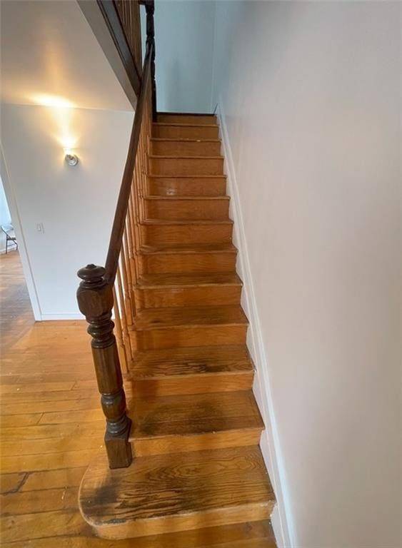 staircase with baseboards and hardwood / wood-style floors