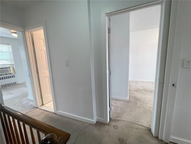 corridor featuring baseboards and carpet flooring